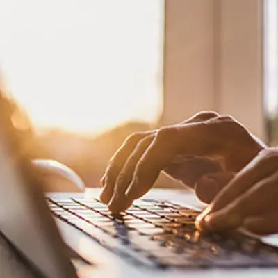 closeup of hands typing on a laptop
